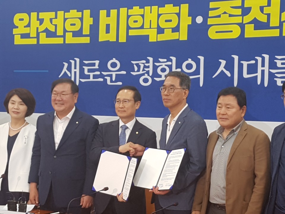 홍영표 더불어민주당 원내대표와 김주영 한국노총 위원장(왼쪽에서 넷째)이 정책협약식에서 악수하고 있다.