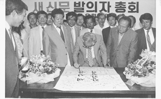 1987년 9월 1일, 서울 안국동 ’새 신문 창간 사무국’ 사무실에서 한겨레 창간 발의자 총회가 열렸다. 송건호가 ’새 신문 창간 발의’라고 붓글씨를 적고 있다. 송건호는 훗날 한겨레신문사 초대 대표이사가 된다. 한겨레 자료사진