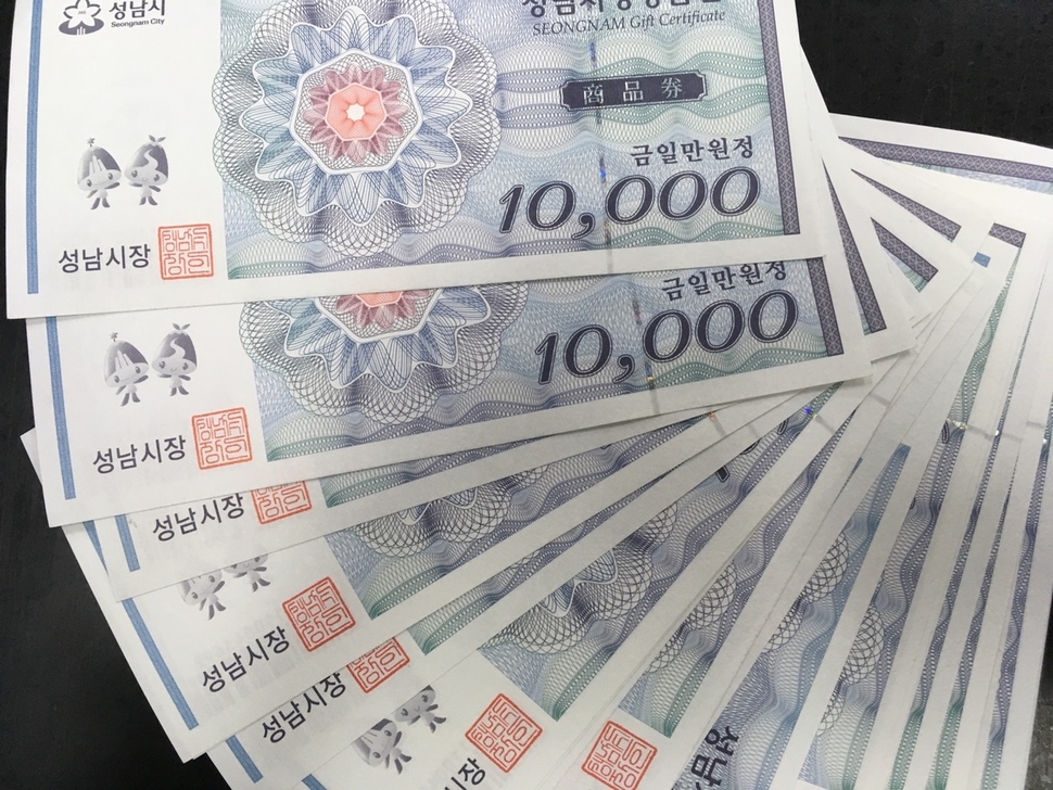 경기도 성남시가 정부 예산으로 지급하는 아동수당을 지역화폐로 주기로 하는 방안에 이어 소득수준과 상관없이 만 6살 미만 아동을 둔 모든 가정에 아동수당을 주는 ‘아동수당 플러스’ 정책을 추진하고 있다. 일부에선 “육아 현실을 외면한 것은 물론 포퓰리즘”이라는 비판을 하고 있지만, 시는 지역경제 활성화와 ‘보편적 복지의 마중물’이라며 관련 조례까지 입법 예고해 논쟁이 벌어지고 있다. 사진은 성남 지역화폐인 성남사랑 상품권.