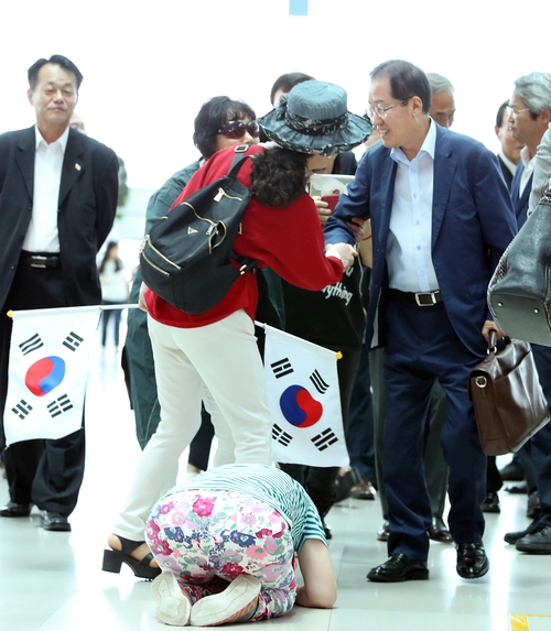 홍준표 자유한국당 전 대표가 미국 출국을 위해 지난 11일 인천공항으로 들어서자 한 지지자가 큰절을 하고 있다. 연합뉴스