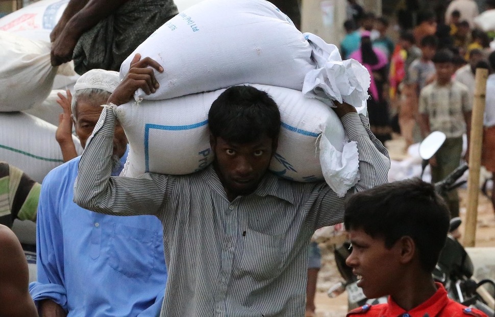 지난 10일(현지시각) 방글라데시 콕스바자르 난민캠프에서 한 로힝야 난민이 배급받은 식량을 짊어져 옮기고 있다. 콕스바자르/김봉규 선임기자 bong9@hani.co.kr
