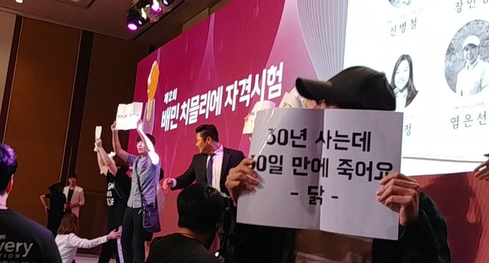 22일 오후 서울 송파구 롯데월드 호텔에서 열린 제2회 배민 치믈리에 자격시험에서 동물운동 활동가들이 기습시위를 벌이고 있다.  시위자들 제공