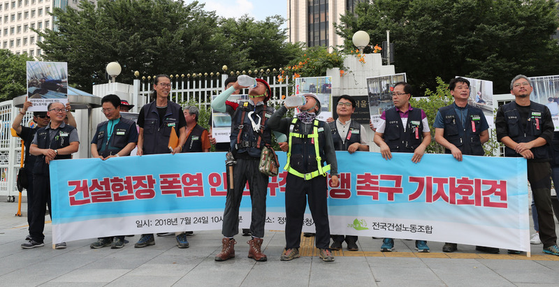 24일 오전 서울 광화문 정부서울청사 앞에서 열린 ‘건설현장 폭염 안전규칙 이행 촉구 기자회견’에 참석한 건설노동자들이 기자회견 도중 물을 마시고 있다. 백소아 기자 thanks@hani.co.kr