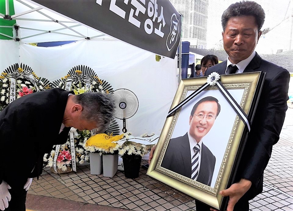 여영국 정의당 경남도당 위원장이 26일 창원 시민분향소에서 김영훈 정의당 ‘노동이 당당한 나라’ 본부장으로부터 고 노회찬 의원의 영정사진을 넘겨받으며 눈물 흘리고 있다.