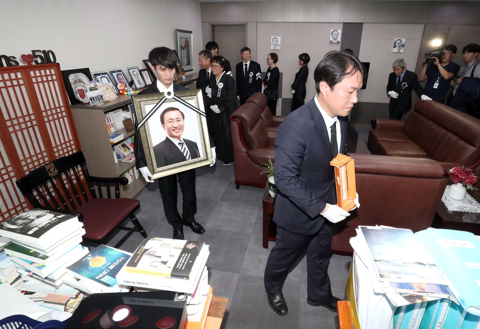 27일 오전 유가족을 비롯해 정의당 이정미 대표와 심상정 의원 등이 뒤따르는 가운데 영결식을 마친 고 노회찬 정의당 원내대표의 영정이 생전에 사용했던 국회 의원회관 사무실을 둘러보고 있다. 공동취재사진