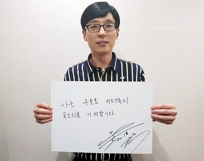 방송인 유재석이 1일 직접 쓴 ‘나는 우토로 어르신들의 목소리를 기억합니다’ 손팻말을 들고 ‘기억할게 우토로' 캠페인을 벌이고 있다. 사진 아름다운재단 제공