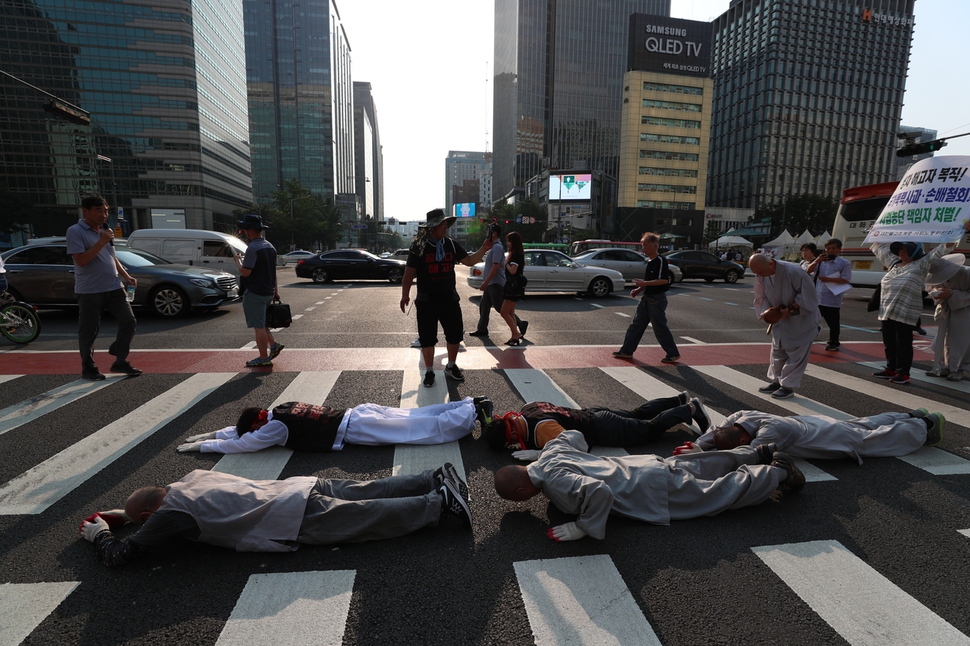 서울 광화문 네거리 횡단보도를 오체투지로 건너는 참가자들. 쌍용자동차 해고노동자와 케이티엑스 승무원, 전국교직원노동조합 조합원, 대한불교조계종 사회노동위원회 스님 등이 2일 오후 서울 견지동 조계사를 출발해 9년 동안 복직을 바라다 절망 속에 스스로 목숨을 끊은 김주중 쌍용차 해고노동자 분향소가 있는 덕수궁 대한문까지 오체투지를 하고 있다. 김정효 기자