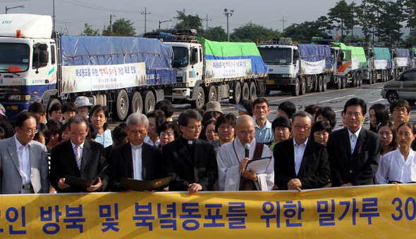 법륜 정토회 지도법사(앞줄 오른쪽 넷째 마이크 든 이)와 개신교, 천주교, 원불교, 천도교 등 종교계 대표들이 2010년 8월 27일 오전 경기 파주 임진각 앞에서 ‘민족의 화해와 평화를 위한 종교인모임’이 마련한 밀가루 300t을 북한에 전달하러 떠나기에 앞서 정부의 대북 인도적 지원을 촉구하고 있다.   파주/신소영 기자 viator@hani.co.kr