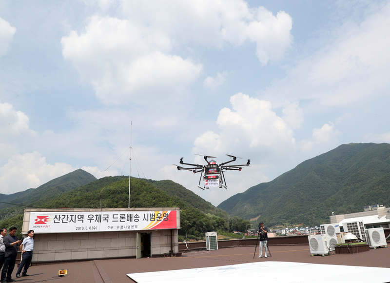 8일 우정사업본부 직원들이 강원 영월군 영월읍 영월우체국에서 2km 떨어진 별마로천문대(오른쪽 산꼭대기)까지 드론을 이용해 택배를 보내는 시연을 하고 있다.우정사업본부 제공