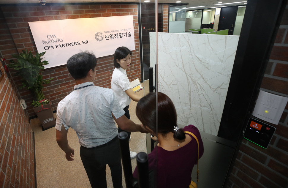 침몰한 보물선으로 알려진 러시아 순양함 ‘돈스코이'호와 관련한 신일그룹의 투자 사기 의혹을 수사하는 경찰의 전담수사팀이 7일 오전 서울 영등포구 여의도동 신일해양기술(전 신일그룹)에 압수수색을 위해 들어가고 있다. 연합뉴스