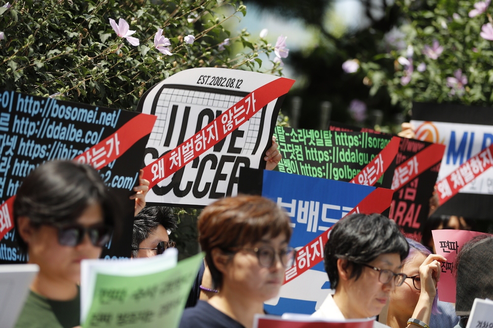 한국여성단체연합 회원들이 10일 오후 서울 서대문구 경찰청 앞에서 경찰 편파수사 규탄 긴급 기자회견을 열어 불법촬영물이 대량 유통되고 있는 남성 중심 온라인 커뮤니티 명단을 쓴 손팻말을 들어보이고 있다. 이정아 기자