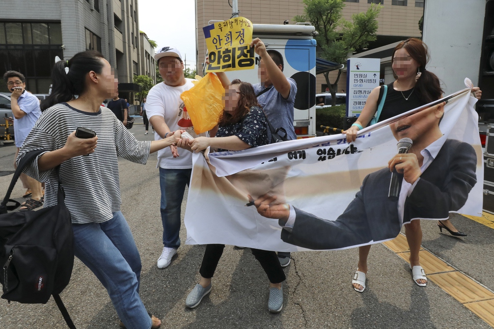 성폭행 등의 혐의로 기소됐던 안희정 전 지사가 1심에서 무죄를 선고받은 14일 서울 마포구 서부지법앞에서 한 여성이 안희정 전 지사를 지지하는 사람들의 플래카드를 뺏으려하고있다. 공동취재사진