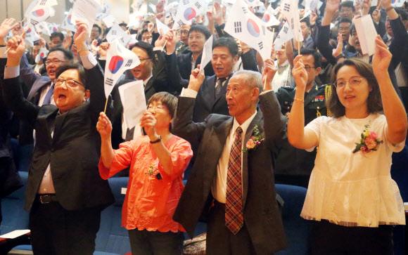 제73주년 광복절을 맞아 15일 중국 베이징 주중 한국대사관에서 열린 광복절 경축식에서 애국지사 김산의 아들 고영광(앞줄 오른쪽 두번째)씨와 작곡가 정율성의 딸 정소제(왼쪽 두번째) 씨가 만세를 부르고 있다. 베이징/연합뉴스