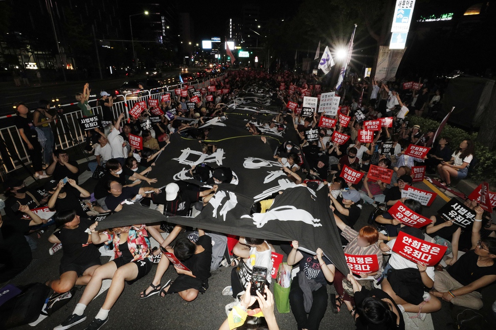 제5차 성차별 성폭력 끝장집회에 참가한 이들이 18일 오후 서울 종로구 신문로 서울역사박물관 앞에서 성차별과 성폭력 관련 단어들을 쓴 대형 펼침막을 찢는 상징의식을 하고 있다. 이정아 기자 leej@hani.co.kr