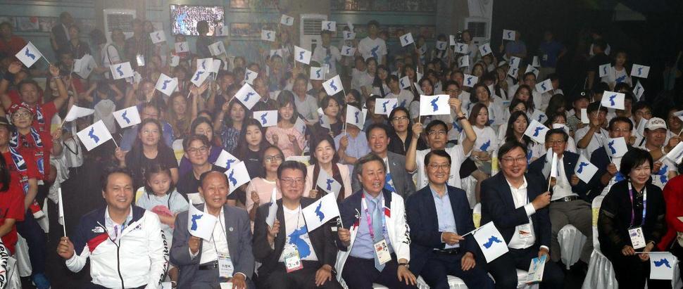 인도네시아 자카르타 팔렘방 아시안게임가 막이 오른 19일 오후 자카르타 수디르만 밀레니아 타워에 마련된 코리아하우스에서 열린 원코리아페스티발에 참석한 신한은행 위성호행장이 응원단과 함께 한반도 단일기를 흔들며 응원을 하고 있다. 이번 2018아시안게임 원코리아공동응원단은 신한은행이 후원을 했다. 사진은 오른쪽부터 이화영 경기도 평화부지사, 위성호 신한은행장, 도종환 문화체육관광부장관, 김덕룡 민주평화통일자문회의 수석부의장, 이창복 2018아시안게임 원코리아 공동응원단  조직위원장, 안민석 문화체육관광위원회 위원장. 자카르타/강창광 기자 chang@hani.co.kr