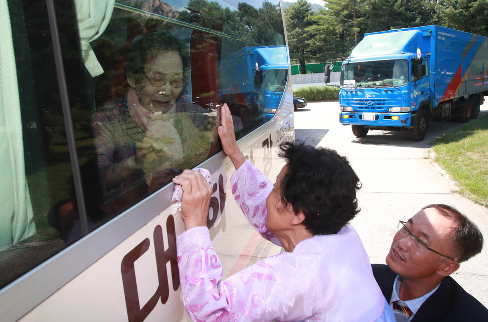 22일 강원도 고성 금강산호텔에서 열린 제21차 이산가족 상봉행사 작별상봉을 마친 한신자(88) 할머니가 버스에 올라타 북쪽에서 온 딸 김경영(71) 할머니에게 손을 흔들며 작별인사하고 있다.