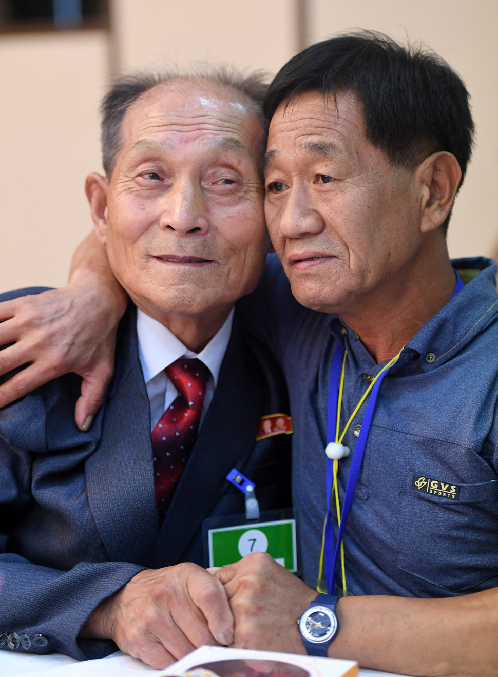 제21차 남북 이산가족 2차 상봉행사 둘째 날인 25일 금강산 면회소에서 열린 단체상봉에서 남쪽 김유철(58·오른쪽)씨가 북쪽 사촌형 김유성(82)씨와 손을 맞잡고 있다. 금강산/사진공동취재단