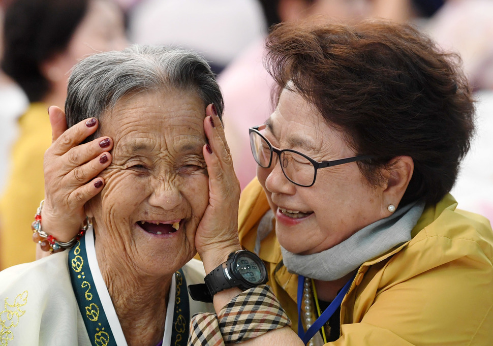 제21차 남북 이산가족 2차 상봉행사 둘째 날인 25일 금강산 면회소에서 열린 단체상봉에서 남쪽 박춘자(77·오른쪽)씨가 북쪽 언니 박봉렬(85)씨 볼을 어루만지며 밝게 웃고 있다. 두 자매는 박춘자씨가 16살 때 헤어졌다 이번 상봉에서 66년 만에 만났다. 금강산/사진공동취재단