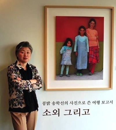 2010년 첫번째 사진 개인전 <콩밝 송학선의 사진으로 쓴 여행 보고서, 소외 그리고> 포스터 앞에 선 송학선 원장의 부인 문혜영씨. 공해추방운동연합과 한살림 창립회원으로 송 원장에 앞서 시민운동을 시작했다.  페이스북 갈무리