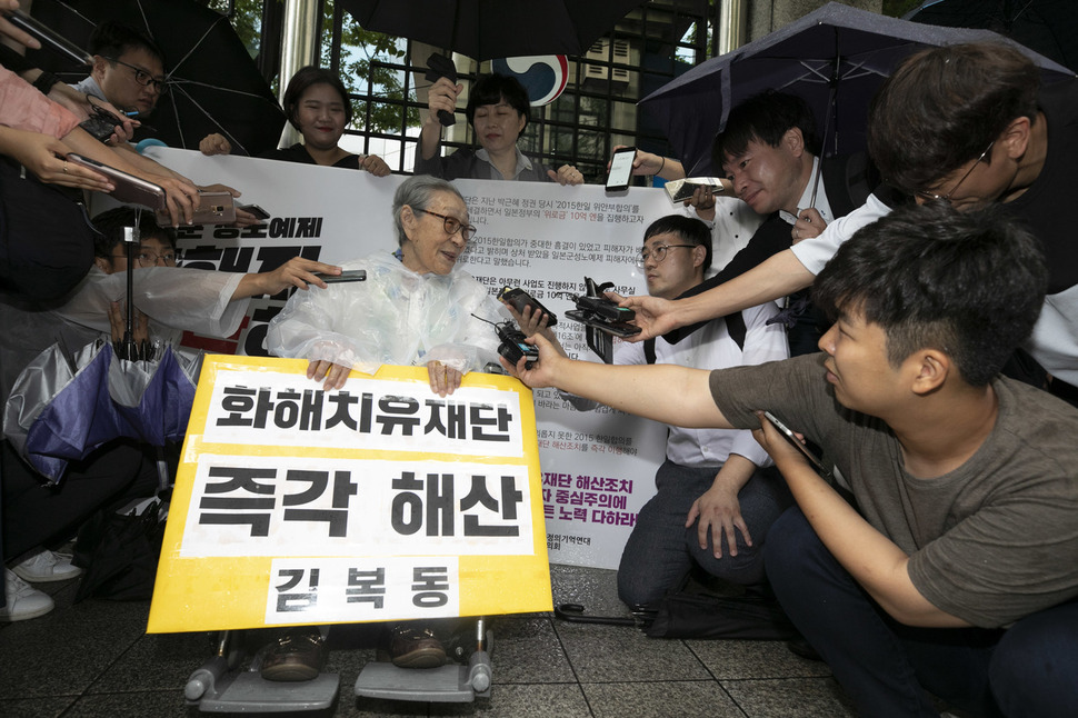 일본군 성노예제 피해자인 김복동 할머니가 3일 오전 서울 종로구 정부서울청사 별관 앞에서 ‘화해치유재단’ 해산을 촉구하며 1인 시위를 벌이던 중 일본인 기자(오른쪽 우산 쓴 이)의 질문에 답하고 있다. 김성광 기자 flysg2@hani.co.kr