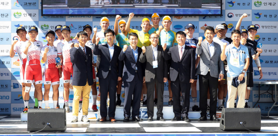 4일 강원도 고성군 통일전망대에서 끝난 ‘투르 드 디엠지 2018 국제청소년 도로사이클 대회’에서 카자흐스탄 주니어팀 등 입상한 선수들이 대회 관계자들과 기념촬영을 하고 있다. 대한자전거연맹 제공