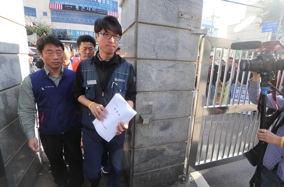 전국금속노동조합 쌍용자동차지부 김득중 지부장(오른쪽)이 10일 오전 전남 여수시 여수시법원을 찾아 박보영 전 대법관과 면담을 위해 판결문을 들고 법원에 들어서고 있다. 쌍용차 해고 노동자들은 박 전 대법간의 출근에 앞서 기자회견을 열어 2014년 쌍용차 정리해고무효소송 기각 등에 사과를 촉구하고 나섰다. 여수/연합뉴스