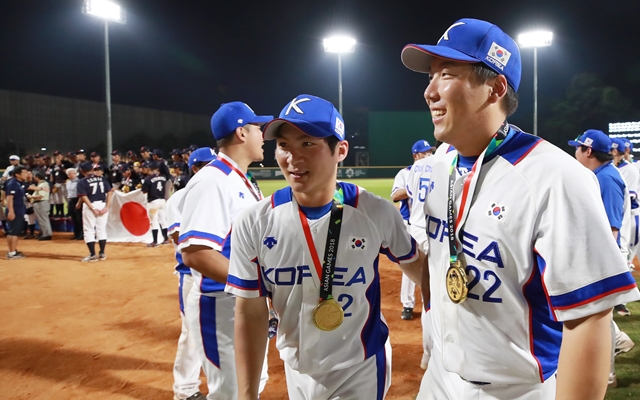 ‘2018 아시안게임’에서 우승한 야구 국가대표팀 오지환(왼쪽), 김현수 선수가 금메달을 목에 걸고 그라운드를 떠나고 있다. 연합뉴스