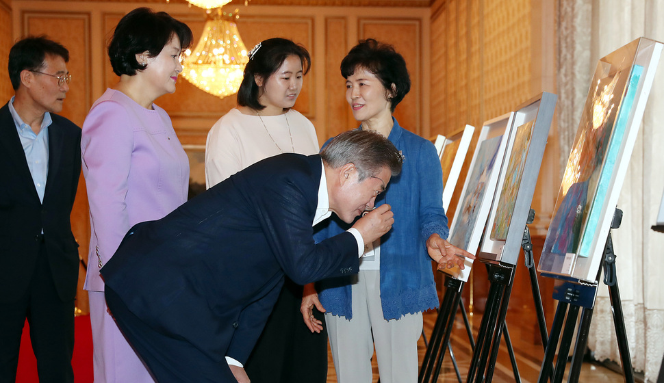 발달장애인 작가 작품 설명 듣는 문 대통령 내외 문재인 대통령과 부인 김정숙 여사가 12일 오전 청와대 영빈관에서 열린 '발달장애인 평생케어 종합대책 발표 및 초청 간담회'에 앞서 발달장애인 작가로 구성된 빛된소리 글로벌 예술협회의 지적장애 3급 박혜신 작가의 작품을 박 작가와 그의 어머니의 설명을 들으며 감상하고 있다. 청와대사진기자단