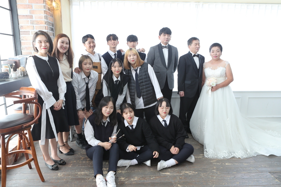 특성화고인 한샘고가 올해부터 학교협동조합을 통해 결혼식을 준비·진행하는 ‘한샘웨딩이야기’를 운영하고 있다. 사진은 한샘고 학생들이 리마인드 웨딩 촬영을 한 어기영·김순식 부부와 함께 기념촬영을 하는 모습. 한샘고 제공