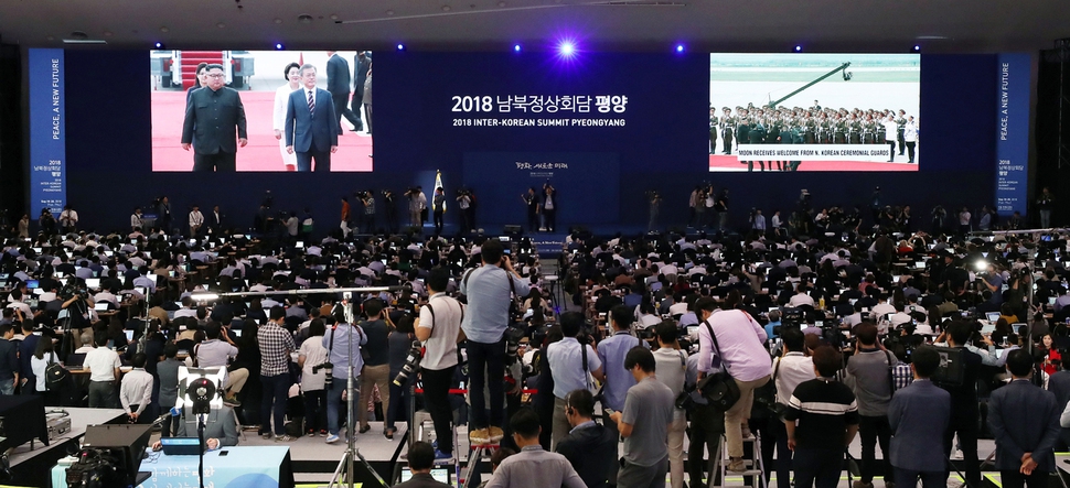 문재인 대통령이 18일 오전 평양국제공항에 도착한 가운데 김정은 국무위원장이 영접을 하고 있는 모습이 생중계 되는 장면을 서울 동대문구 ‘2018 남북정상회담 평양 서울프레스 센터’에 모인 내외신 기자들이 지켜보고 있다. 평양사진공동취재단