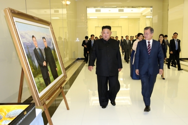 문재인 대통령과 부인 김정숙 여사, 김정은 국무위원장과 부인 리설주 여사가 18일 오후 평양 목란관에서 열린 남북정상회담 환영 만찬장으로 향하고 있다. 사진 왼쪽으로 김 위원장이 문 대통령에게 전달한 선물이 전시돼 있다. 평양사진공동취재단