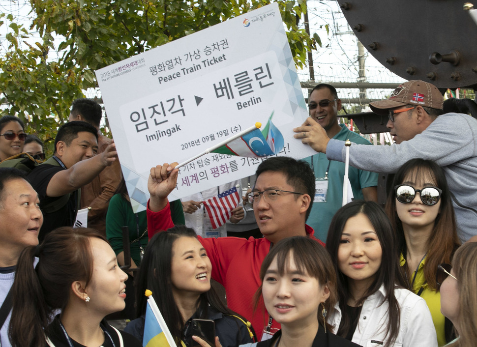 '2018 세계한인차세대대회'에 참석하기 위해 전 세계 24개국에서 온 재외동포 80여명이 19일 오전 경기도 파주시 임진각 경의선 장단역 증기기관차 앞에서 열린 한반도 평화 기원 행사에 참석해 임진각과 베를린을 잇는 가상 평화열차승차권을 서로에게 건네고 있다. 파주/김성광 기자 flysg2@hani.co.kr