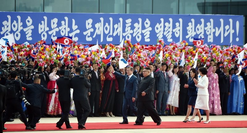 문재인 대통령과 김정숙 여사가 지난 18일 오전 평양 순안공항에 도착한 뒤, 김정은 국무위원장 부부와 함께 걸으며 평양 시민들의 환영을 받고 있다. ‘문재인 대통령을 열렬히 환영한다’는 내용의 푸른색 대형 펼침막이 눈길을 끈다. 평양사진공동취재단/김정효 기자 hyopd@hani.co.kr