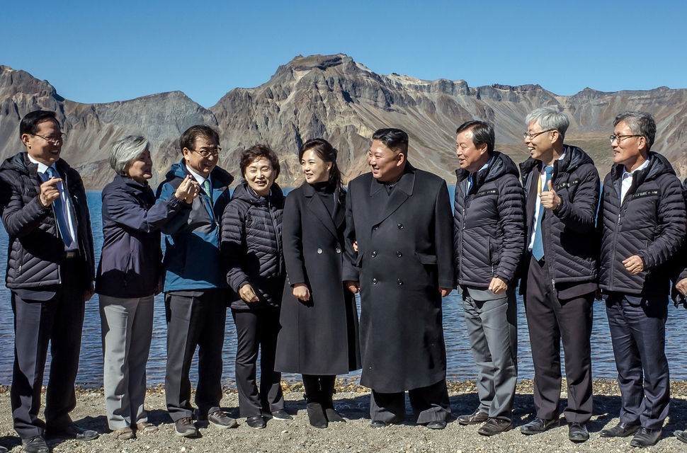 김정은 북한 국무위원장과 리설주 여사가 20일 백두산 천지에서 남쪽 수행원들과 기념사진을 찍던 중 강경화 외교부 장관으로부터 "남쪽에서 유행하는 손가락 하트를 해보자"는 제안을 받고 있다. 청와대 제공