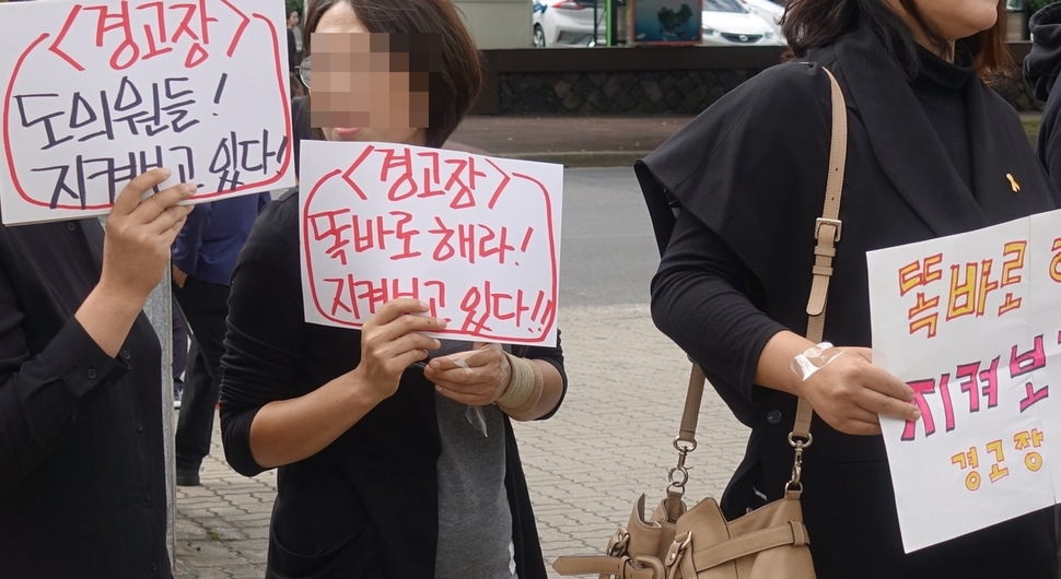 제주시민들이 27일 제주도의회 앞에서 최근 신화역사공원 행정사무조사를 부결시키고 해외연수를 떠난 의원들을 규탄하고 있다. 허호준 기자