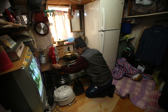 한 노인이 서울 용산구 동자동의 한 쪽방촌 자신의 방에서 점심식사를 준비하고 있다. 이정아 기자 leej@hani.co.kr