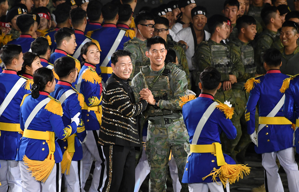 1일 오후 서울 용산 전쟁기념관 평화의 광장에서 열린 제70주년 국군의날 기념식에서 가수 싸이가 군복무중인 투피엠의 옥택연과 만나 악수하고 있다. 청와대사진기자단