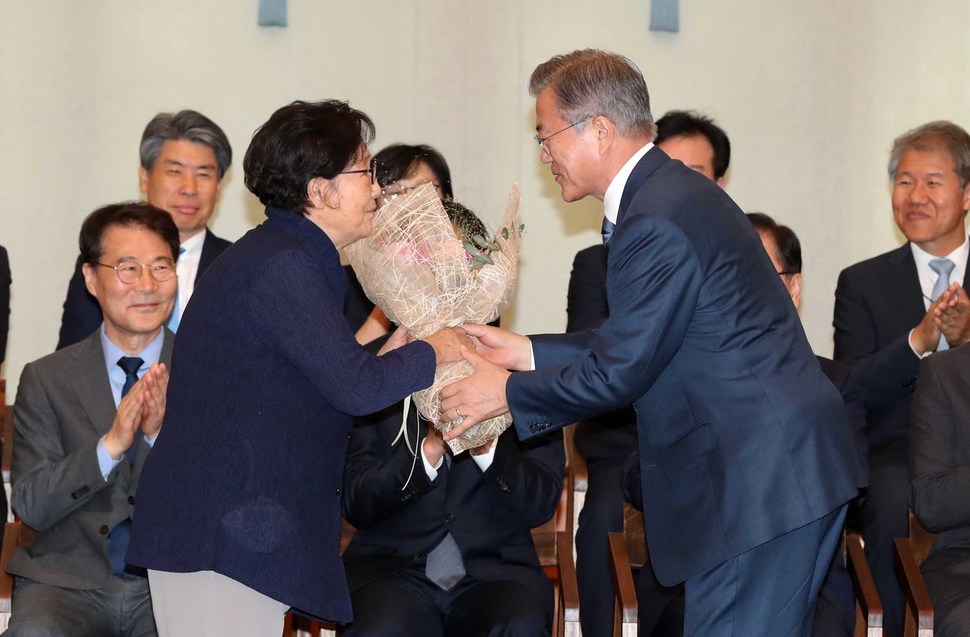 문재인 대통령이 2일 청와대에서 유은혜 사회부총리 겸 교육부 장관의 시어머니 정종석 씨에게 꽃다발을 전달하고 있다. 청와대사진기자단