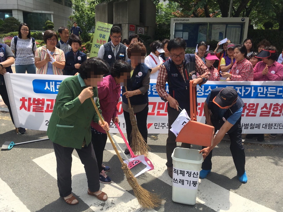 지난해 5월 부산 연제구 부산지방고용노동청 들머리에서 청소노동자들이 비정규직, 차별, 인권유린 등의 글이 적힌 종이를 ‘적폐청산 쓰레기통’에 담아 버리는 퍼포먼스를 하고 있다. 민주노총 부산본부 제공