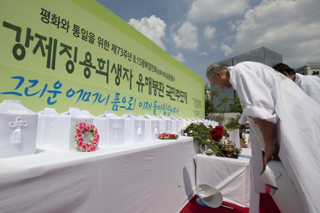 '일제강제징용희생자 유해봉환 국민추모제'가 지난 8월15일 오후 서울 종로구 광화문광장에서 열려 참석자들이 제단 위에 놓인 희생자 35위를 향해 묵념하고 있다. 김성광 기자 flysg2@hani.co.kr