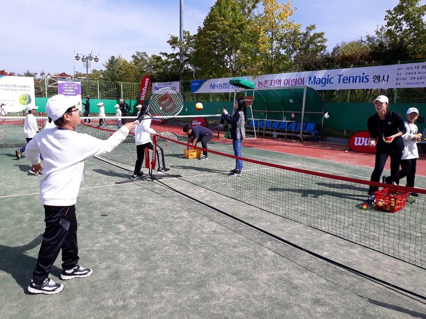 여자프로테니스(WTA) 투어 2018 코리아오픈 여자복식 챔피언인 최지희(오른쪽·NH농협은행)가 8일 전주 전북도청 테니스코트에서 고창·부안군 농촌지역 어린이들에게 발리를 가르쳐 주고 있다.