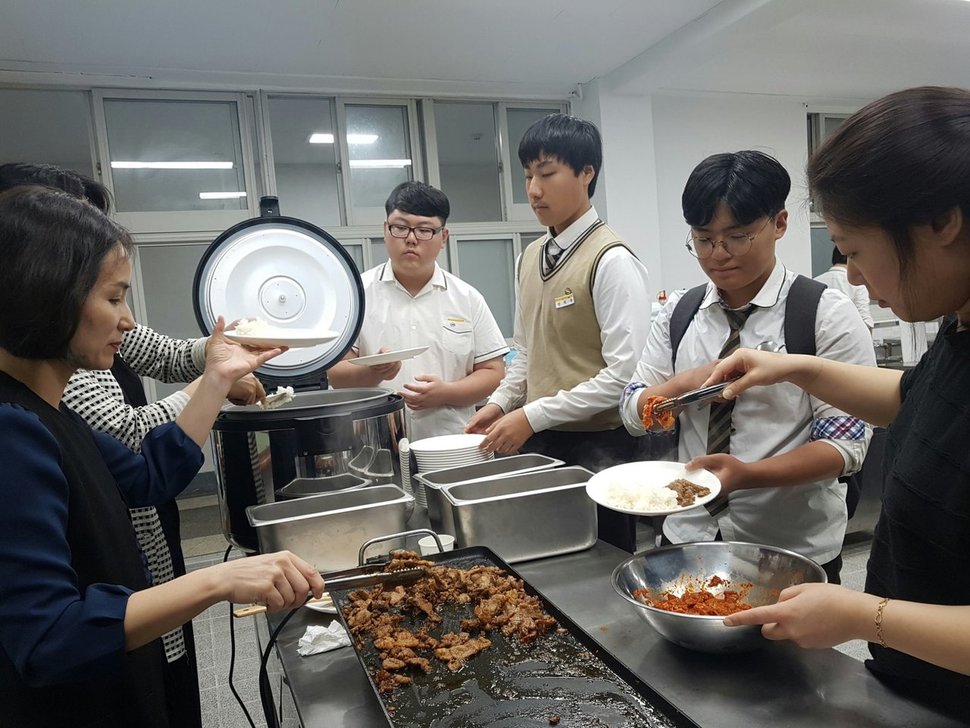 지난 1일 아침 부산 영산고 조리실에서 교사들이 그룻에 직접 지은 밥과 반찬을 담아주고 있다. 영산고 제공