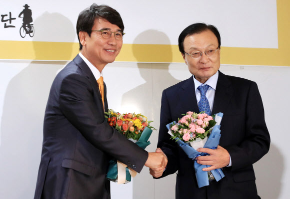 더불어민주당 이해찬 대표(오른쪽)가 15일 오전 서울 마포구 노무현재단 사무실에서 열린 이사장 이·취임식에 후임 이사장인 유시민 전 보건복지부 장관과 악수하고 있다. 2018.10.15 연합뉴스