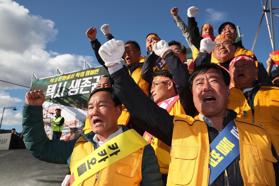 카카오의 카풀 서비스에 반대하는 전국 택시 산업 종사자들이 18일 서울 광화문광장에서 열린 ‘택시 생존권 사수 결의대회’에서 구호를 외치며 집회를 열고 있다. 김봉규 선임기자 bong9@hani.co.kr