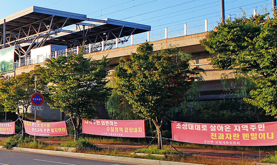 역 앞의 식당들이 단속으로 문을 닫은 뒤 평일에는 오가는 이 조차 드문 운길산역 풍경. 주민들이 내건 현수막은 조안면의 현실이자 희망이다.