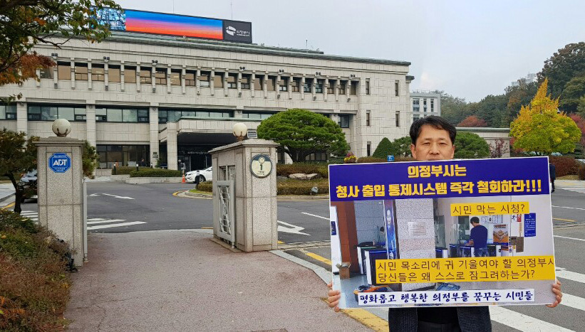 김성훈 의정부경전철시민모임 대표가 23일 오전 경기 의정부시청 정문 앞에서 청사 출입 통제시스템 철회를 요구하는 1인 시위를 벌이고 있다. 의정부시청사 출입통제시스템 반대모임 제공
