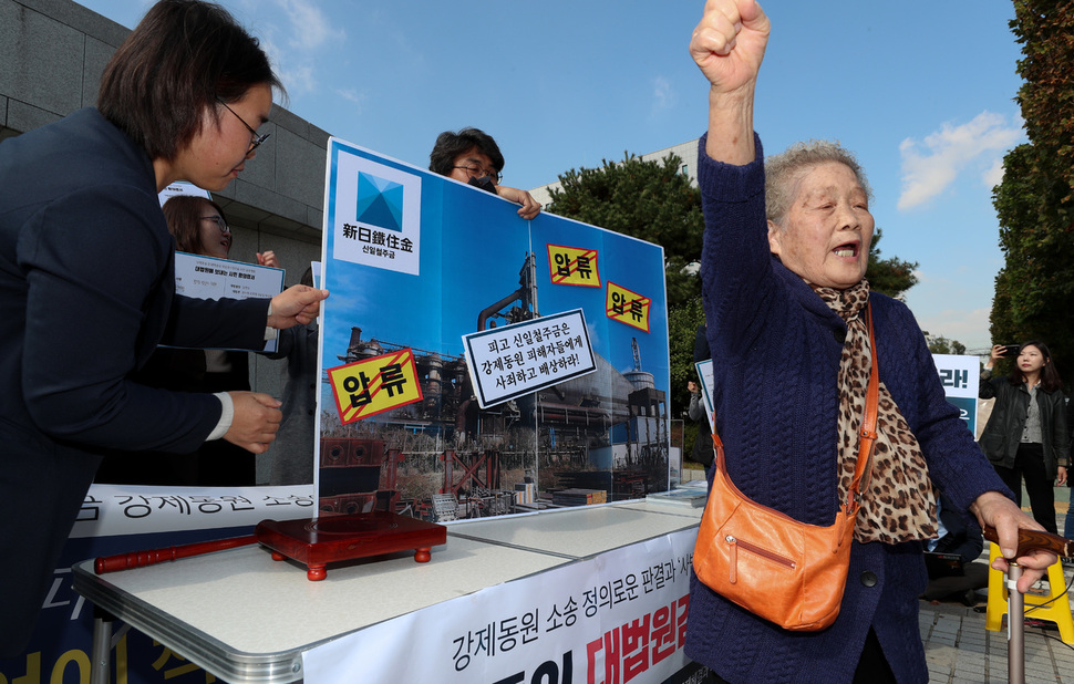 ‘강제동원 문제해결과 대일과거청산을 위한 공동행동’이 24일 오전 서울 서초동 대법원 앞에서 연 기자회견 뒤 ‘신일철주금’ 공장 사진에 압류스티커를 붙이는 행위극을 하는 동안 후지코시 근로정신대 소송 원고인 김정주 할머니가 일본기업의 사죄와 배상을 요구하는 구호를 외치고 있다. 김정효 기자 hyopd@hani.co.kr