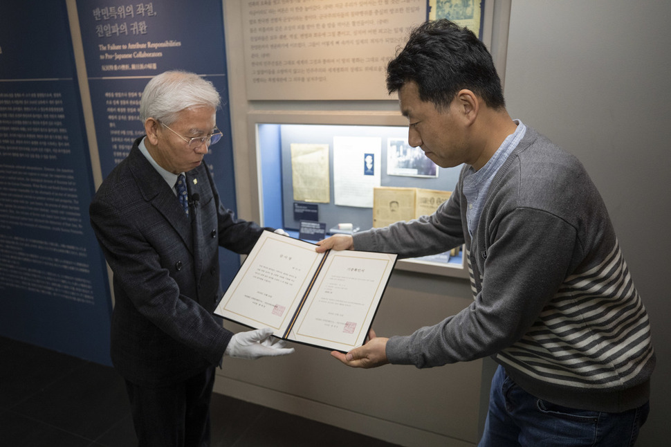 박기서(왼쪽)씨가 24일 오전 서울 용산구 식민지역사박물관에서 백범 김구 선생 암살범 안두희를 처단하는데 쓰인 ‘정의봉’과 글귀가 적힌 종이를 함께 기증하고 있다. 김성광 기자