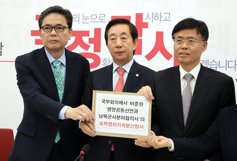 김성태 자유한국당 원내대표(가운데)가 24일 국회 원내대표실에서 곽상도(왼쪽), 최교일(오른쪽) 의원과 함께 긴급 기자회견을 하며 ‘국무회의에서 비준한 평양공동선언과 남북군사합의서의 효력정지가처분 신청서’를 들어 보이고 있다. 연합뉴스