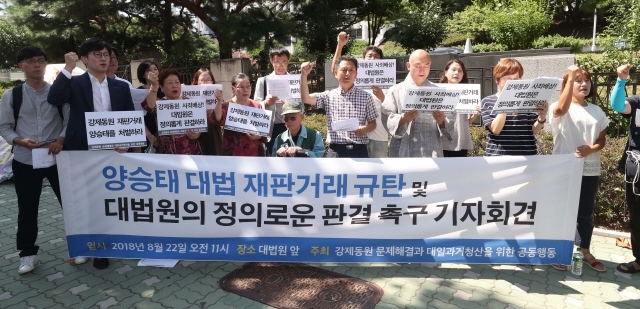 지난8월 서울 서초동 대법원 앞에서 열린 ‘양승태 대법 재판거래 규탄 및 일제 강제동원 피해 소송 전원합의체 심리재개에 대한 긴급 기자회견’에서 참가자들이 구호를 외치고 있다. <한겨레> 자료 사진